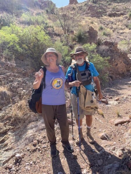 two smiling rockhounds with mountainous desert background